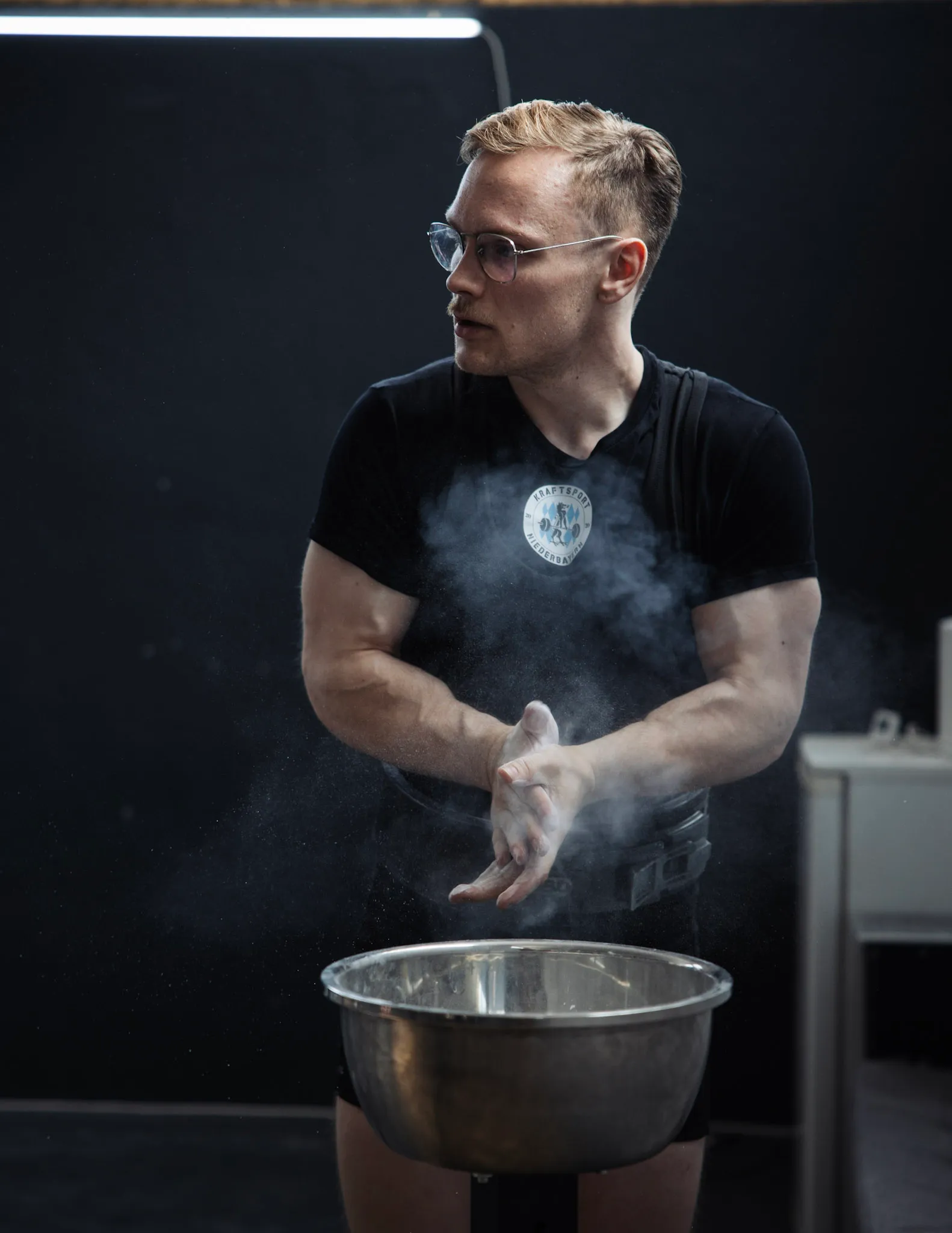 Athlet im KSNB Shirt reibt sich vor dem Satz die Hände mit Magnesia ein
